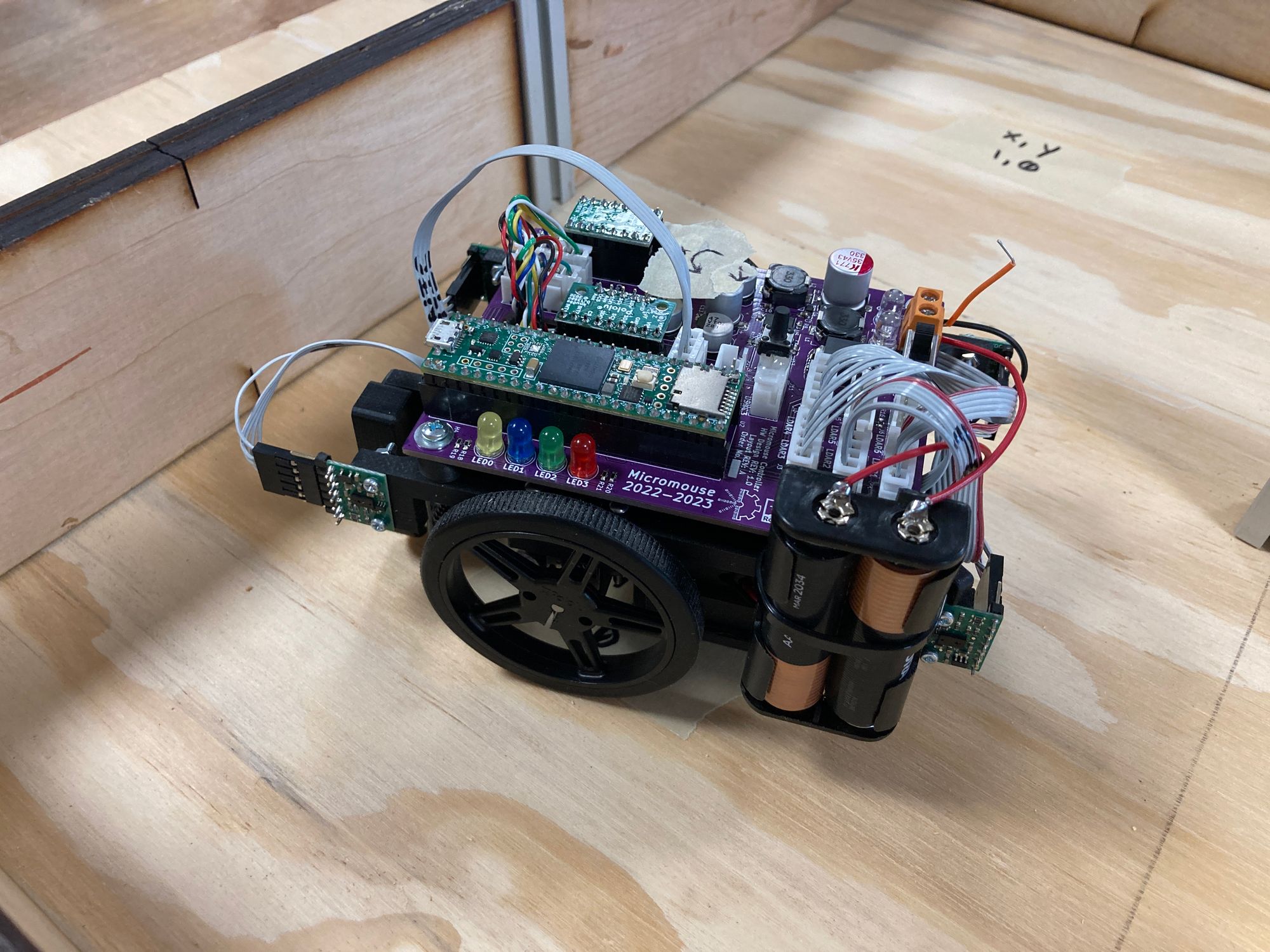 A picture of a small robot with two wheels and exposed wires